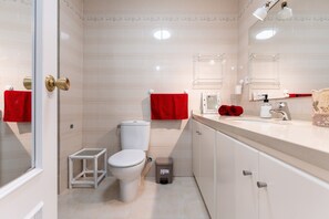 Une salle de bain moderne avec des toilettes, un lavabo et un miroir.