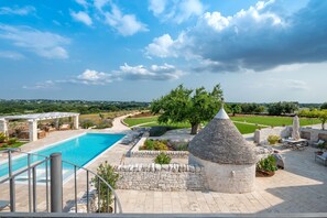 Una piscina con una estructura de piedra, mobiliario exterior y vistas al paisaje.