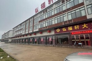 A multi-story building with a prominent red sign on the facade. - Hongfuxuan Hotel (Jurong)