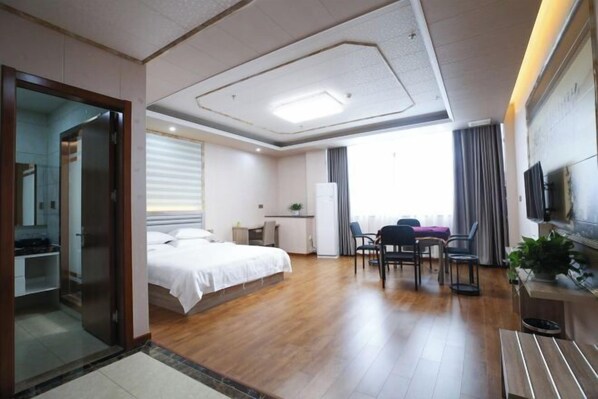 A modern hotel room with a large bed, a desk, a chair, and a TV. - Hongfuxuan Hotel (Jurong)