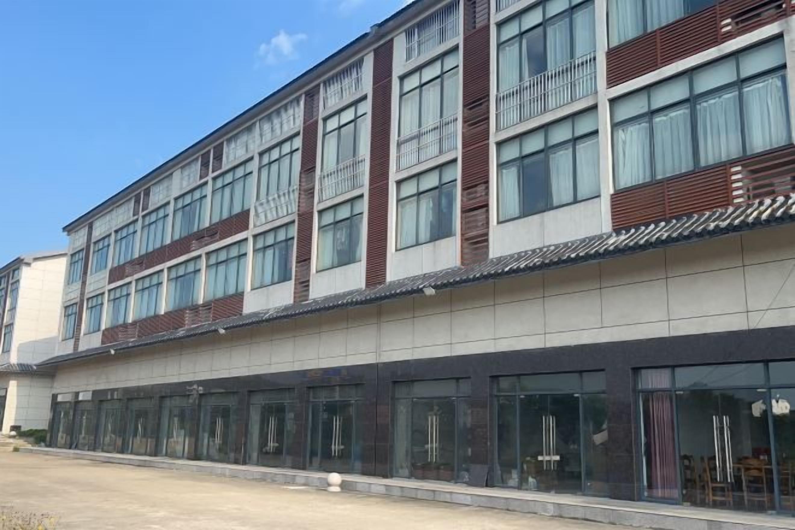 A modern building with multiple floors, large windows, and a flat roof.