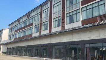 A modern building with multiple floors, large windows, and a flat roof.