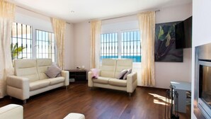 Ein geräumiges Wohnzimmer mit zwei Sofas, einem Fernseher und einem Kamin.