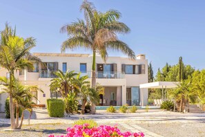 A modern two-story building with a pool, surrounded by palm trees and a well-maintained garden. - Limni Beach Villa - Four Bedroom Villa, Sleeps 8 (Polis)