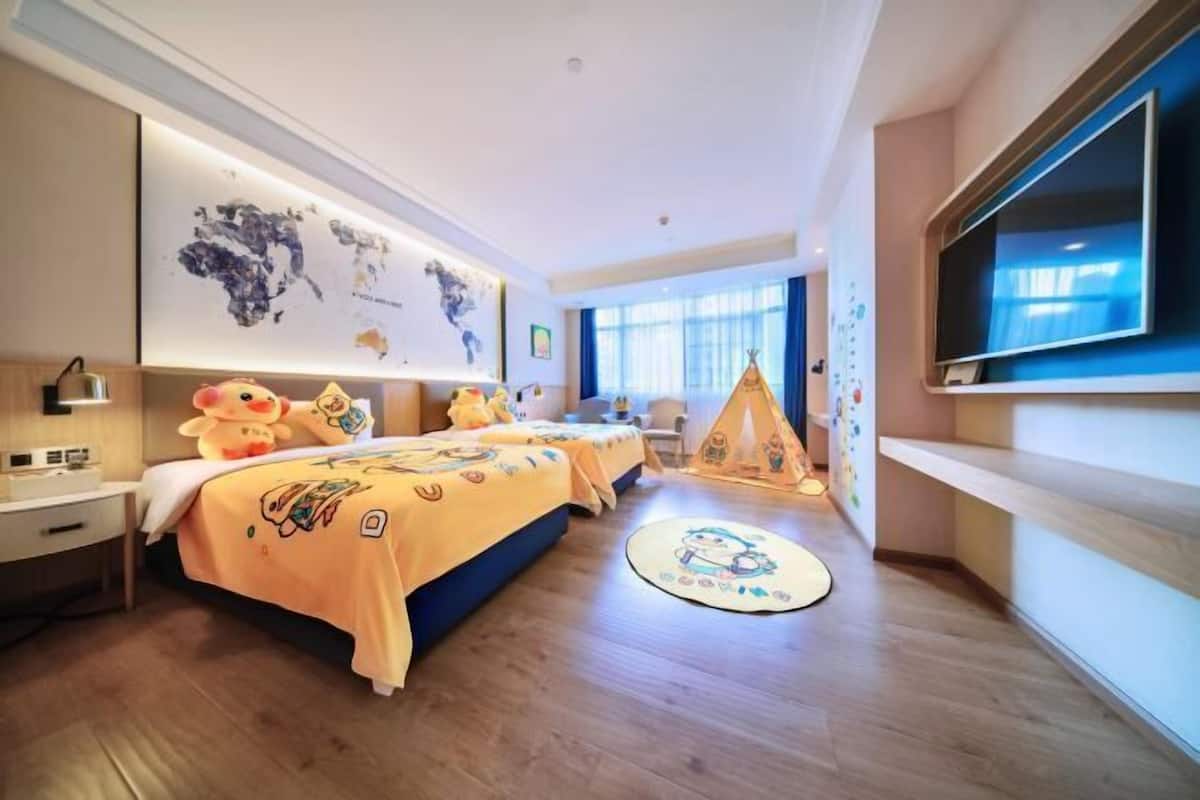 A hotel room with a large bed, a TV, a map on the wall, and a tent-like structure.