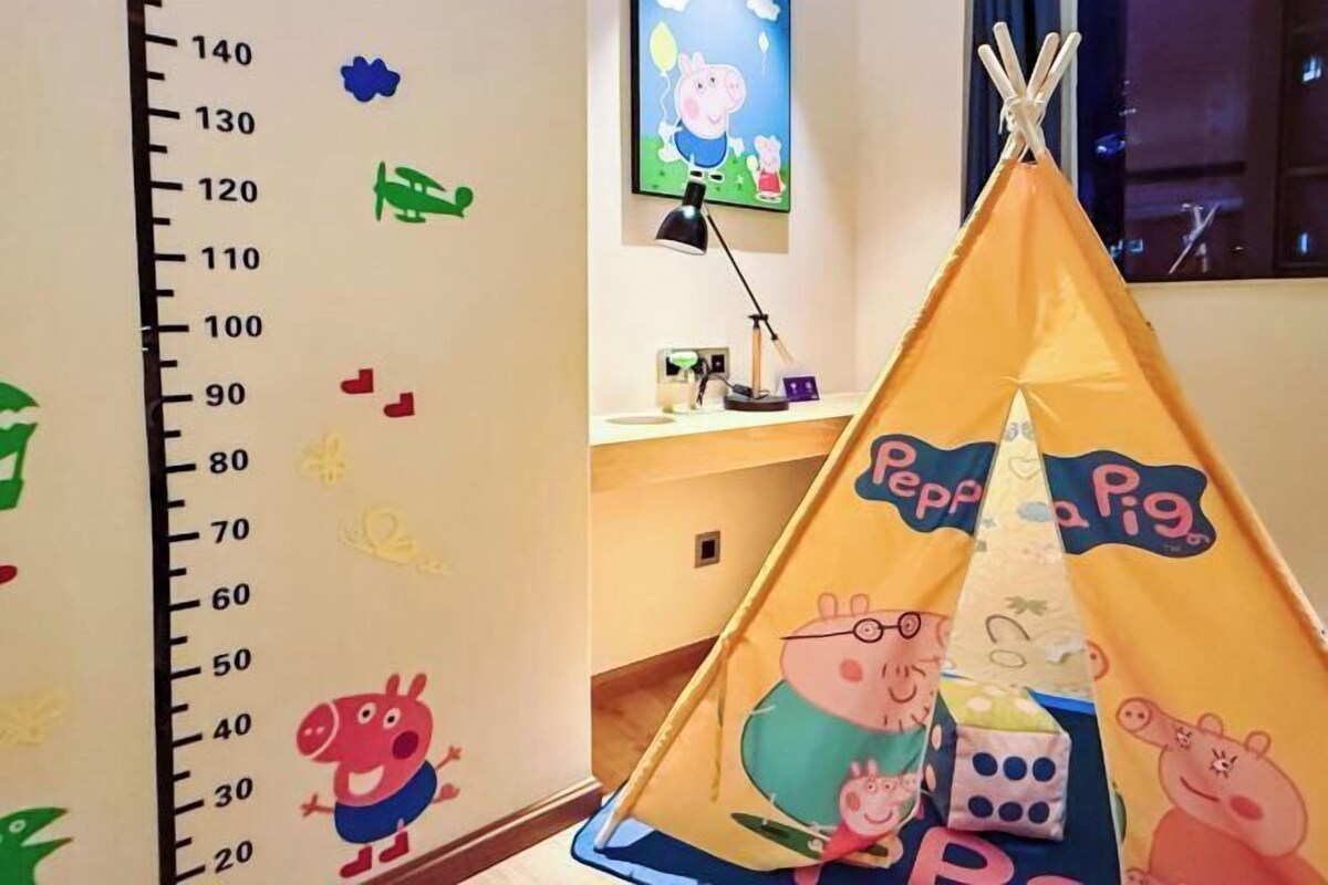 A children's play area with a height chart, a Peppa Pig-themed tent, and wall decorations.