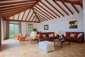 Relax in this spacious living room with a high ceiling, two sofas, and a coffee table.