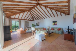 Relax in this open-plan living area with a sofa set and TV.