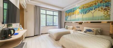A hotel room with two beds, a desk with a coffee maker, a TV, and a painting on the wall.