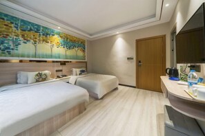 Una habitación de hotel con cama, un escritorio pequeño, una silla, un espejo y un cuadro en la pared.