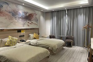 Habitación de hotel con dos camas, un escritorio, una silla, perchero y un cuadro abstracto grande en la pared.