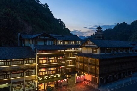 A traditional Japanese building with multiple floors, a pagoda-like structure, and illuminated signage.. Longsheng Yuntian Grand Hotel