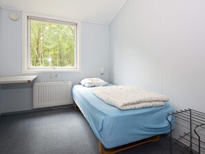 A small, single-bed room with a window, a radiator, and a bedside table. - 20 Person Holiday Home in Herning (Herning)