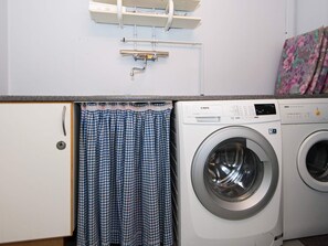 A laundry area with a washing machine, a drying rack, and a curtain. - 20 Person Holiday Home in Herning (Herning)