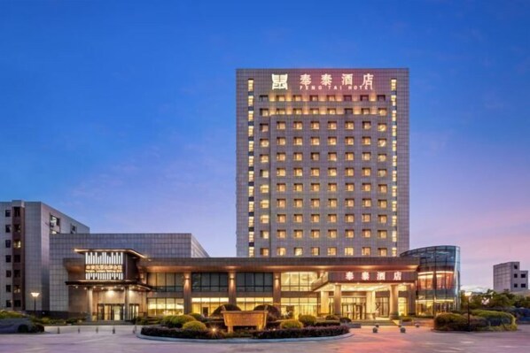 A modern hotel building with a prominent sign at the top.