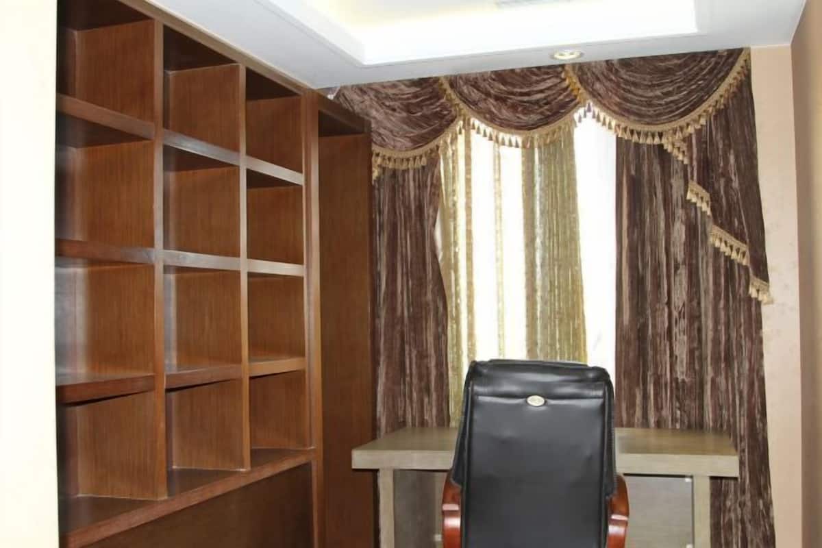 A room with a wooden bookshelf, a desk, and a chair.