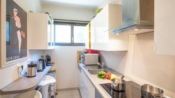 Eine moderne Küche mit Backofen, Spüle und Fenster.