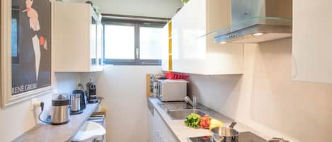Een moderne keuken met een inbouwoven, een spoelbak en een raam.
