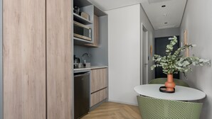 A compact kitchen with wooden cabinets, a built-in microwave, and a sink. - One Thibault 1910 (Cape Town)