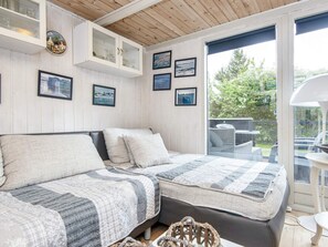 A cozy room with a large bed, a wooden ceiling, and a view of the outdoors through a glass door. - 5 Person Holiday Home in Hovborg (Hovborg)