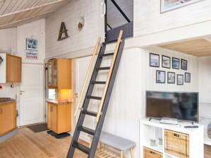 A room with a wooden ladder leaning against a wall, a television on a white stand, and a door with a 'Please DO NOT DISTURB' sign. - 5 Person Holiday Home in Hovborg (Hovborg)