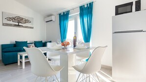 A modern kitchen with white cabinetry, a built-in microwave, and a refrigerator. - Apartment Darija in Omišalj with splendid sea view (Omisalj)