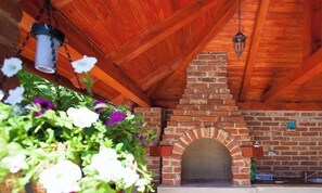 Une cheminée en briques, un plafond en bois et des lanternes suspendues.