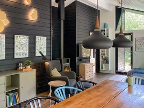 Uma sala de estar moderna com lareira, móveis de madeira e obras de arte nas paredes.