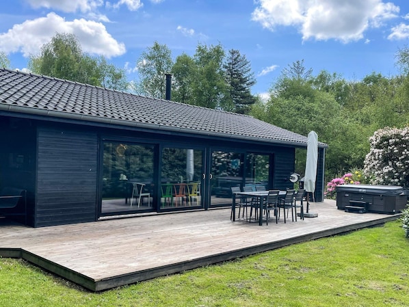 A modern building with a flat roof, large glass windows, and a wooden deck. - 5 Star Holiday Home in Bogense (Bogense)
