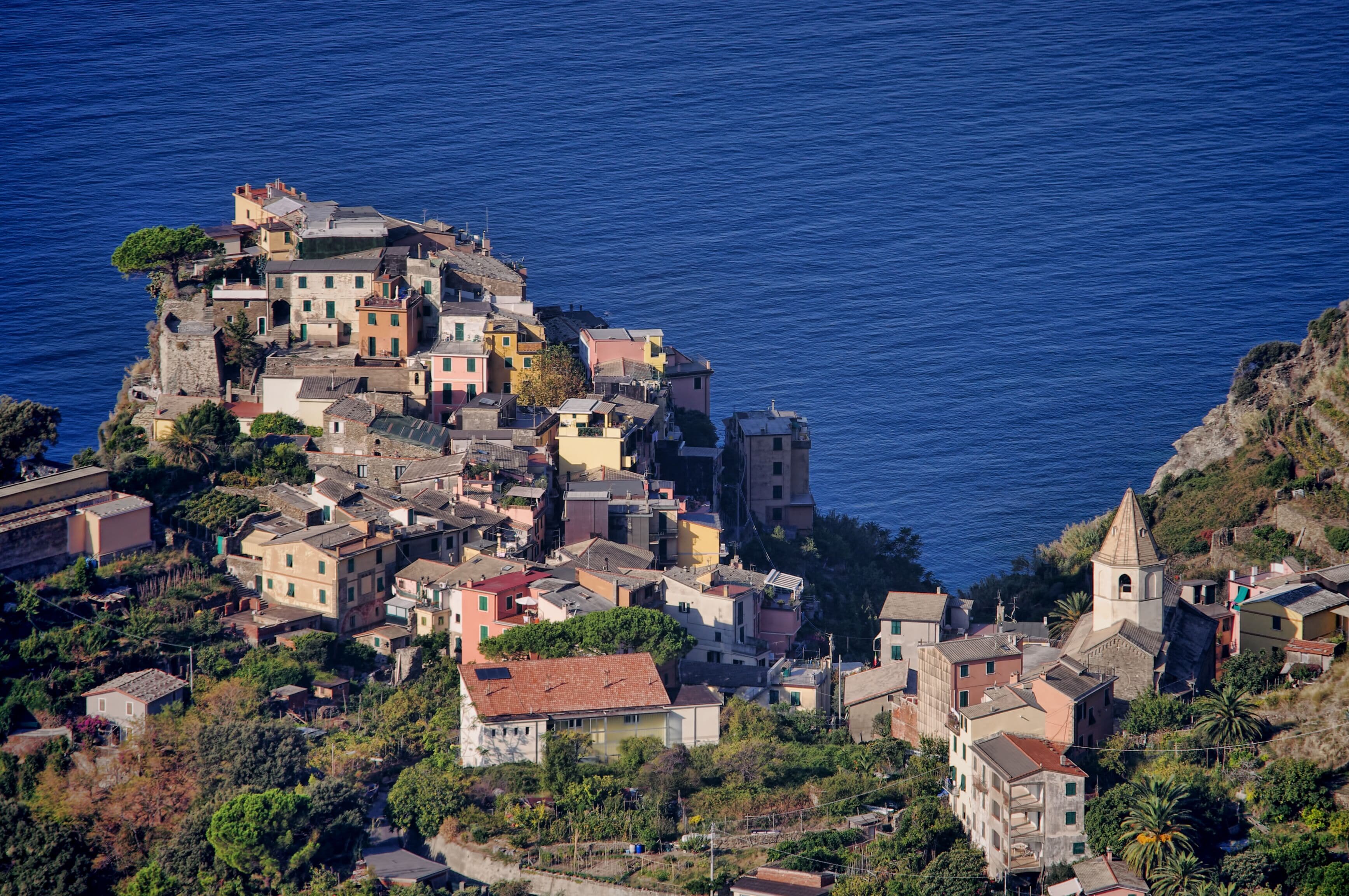 A coastal village with buildings clustered on a hillside overlooking the sea.