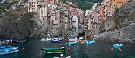 Un pueblo costero con edificios de colores y barcos amarrados en el agua.