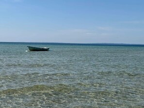 A calm sea with a boat floating on the water. - 6 Person Holiday Home in Knebel (Knebel)