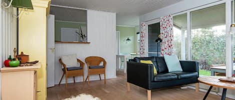 Et værelse med en sofa, to stole, et bord og en ottomane betrukket med pels.