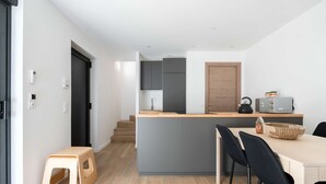 A modern kitchen with grey cabinets, a wooden island, and a dining area with black chairs. - La Maison du Parc 2 Standing Paarking Clim downtown (Marseille)