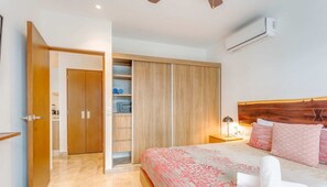 Une chambre à coucher comprenant un lit, une armoire, une table de chevet et un appareil de climatisation.