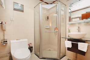 A corner bathroom with a glass-enclosed shower, a white toilet, a glass sink with a white basin, and a mirror above the sink. - Jianfu Hotel (Chongqing)