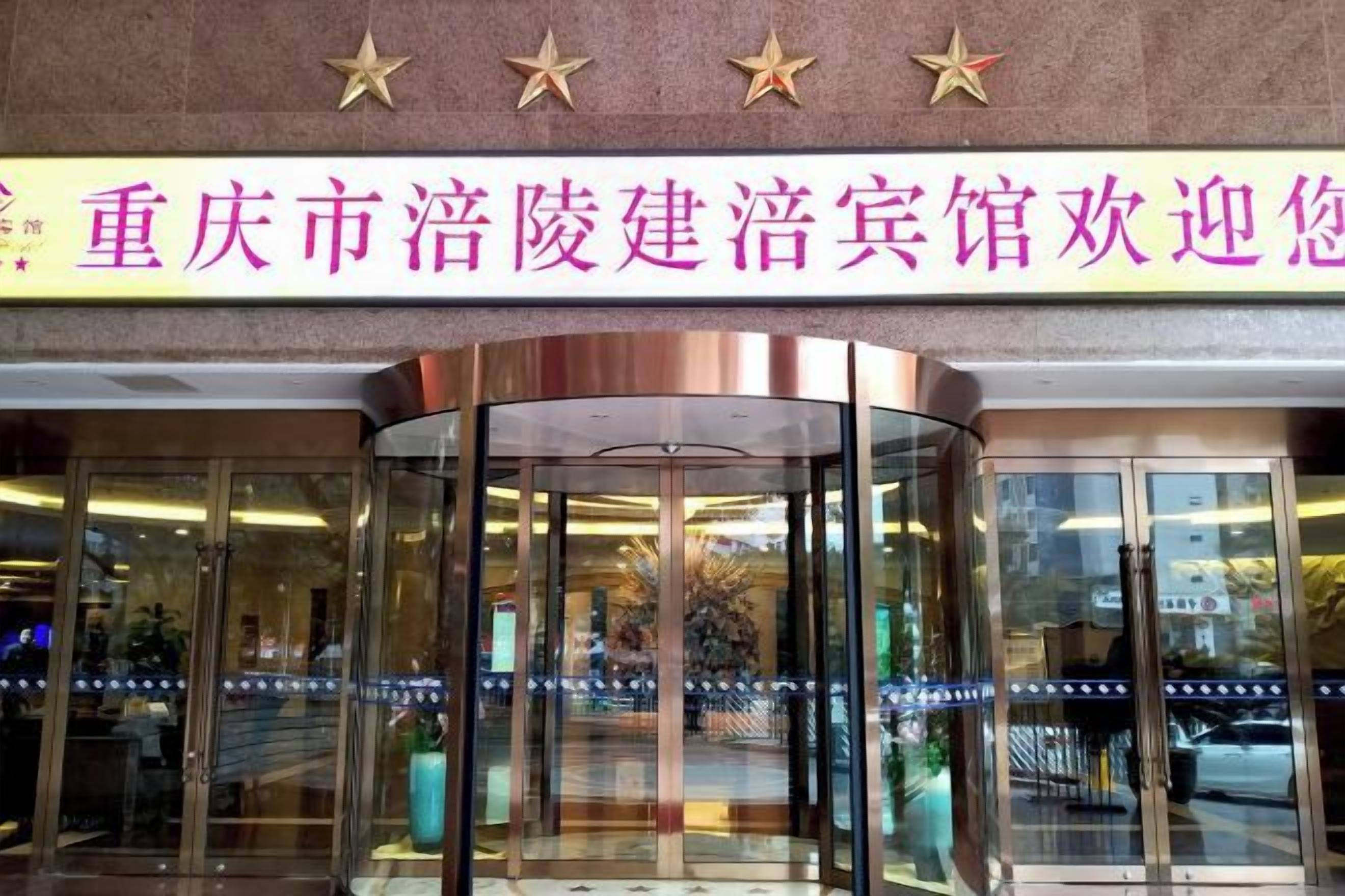 A hotel entrance with a revolving door and a sign above it.