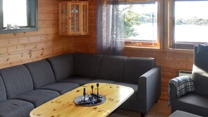 A cozy living room with a wooden table, grey sofas, and a cabinet. - 6 Person Holiday Home in Bud (Hustadvika)