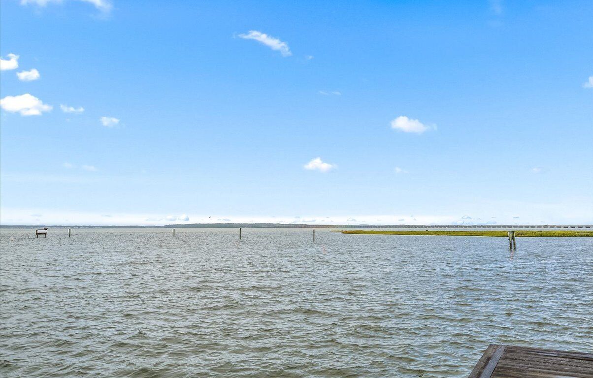 A calm body of water with a wooden dock extending into it.