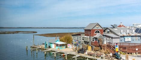 A waterfront property with a dock, a small building with a red roof, and a signboard.