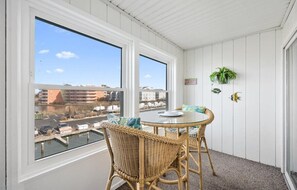 Enjoy the serene marina views from this balcony with a glass table and wicker chairs.