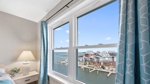 A bedroom with a large window overlooking a dock and boats. - Great Midtown Location with Water Views! (Ocean City)