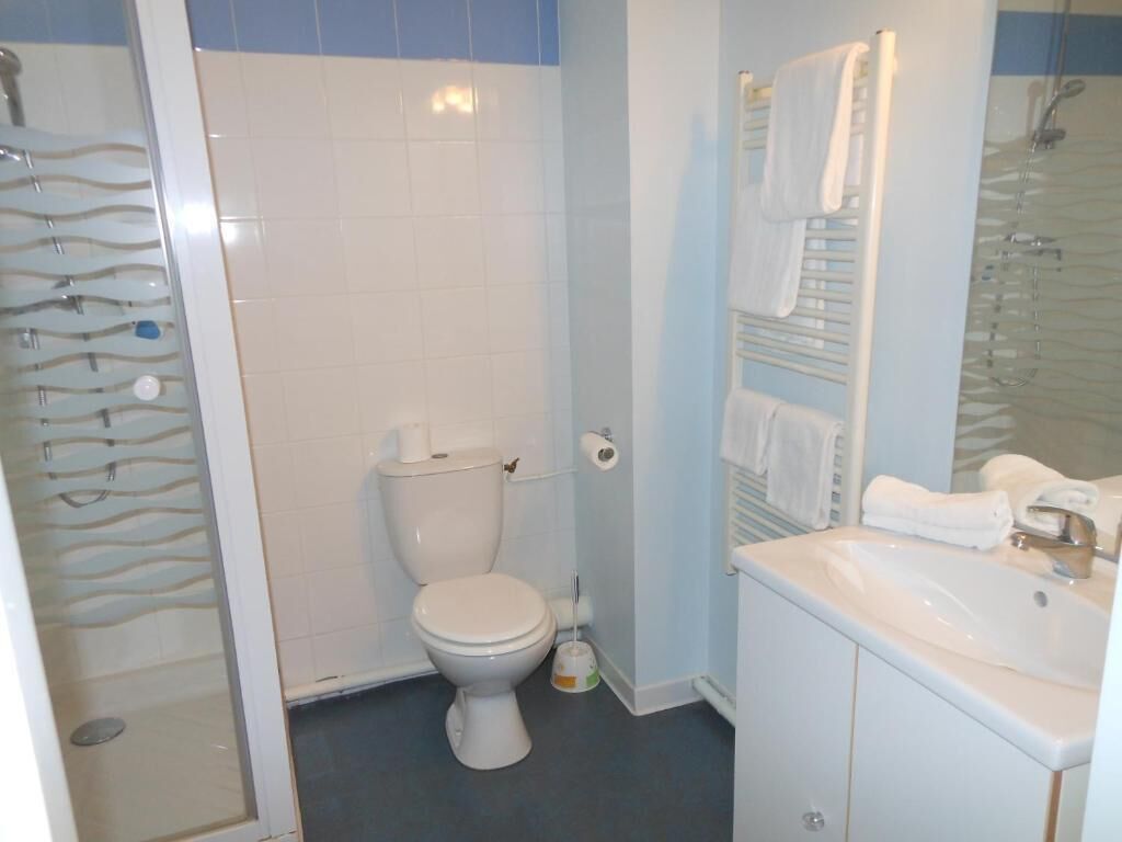 A bathroom with a toilet, a sink, and a shower area.