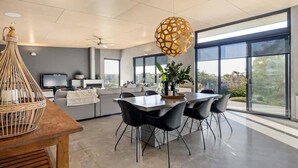 Eine moderne Küche mit Essbereich, großen Fenstern und Blick ins Freie.