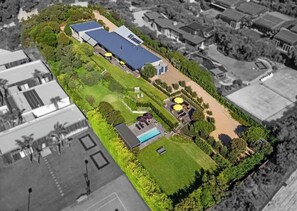An aerial view of a property with a large building, a swimming pool, and surrounding greenery. - Portsea Sanctuary, Gas Heated Pool & Gardens (Portsea)