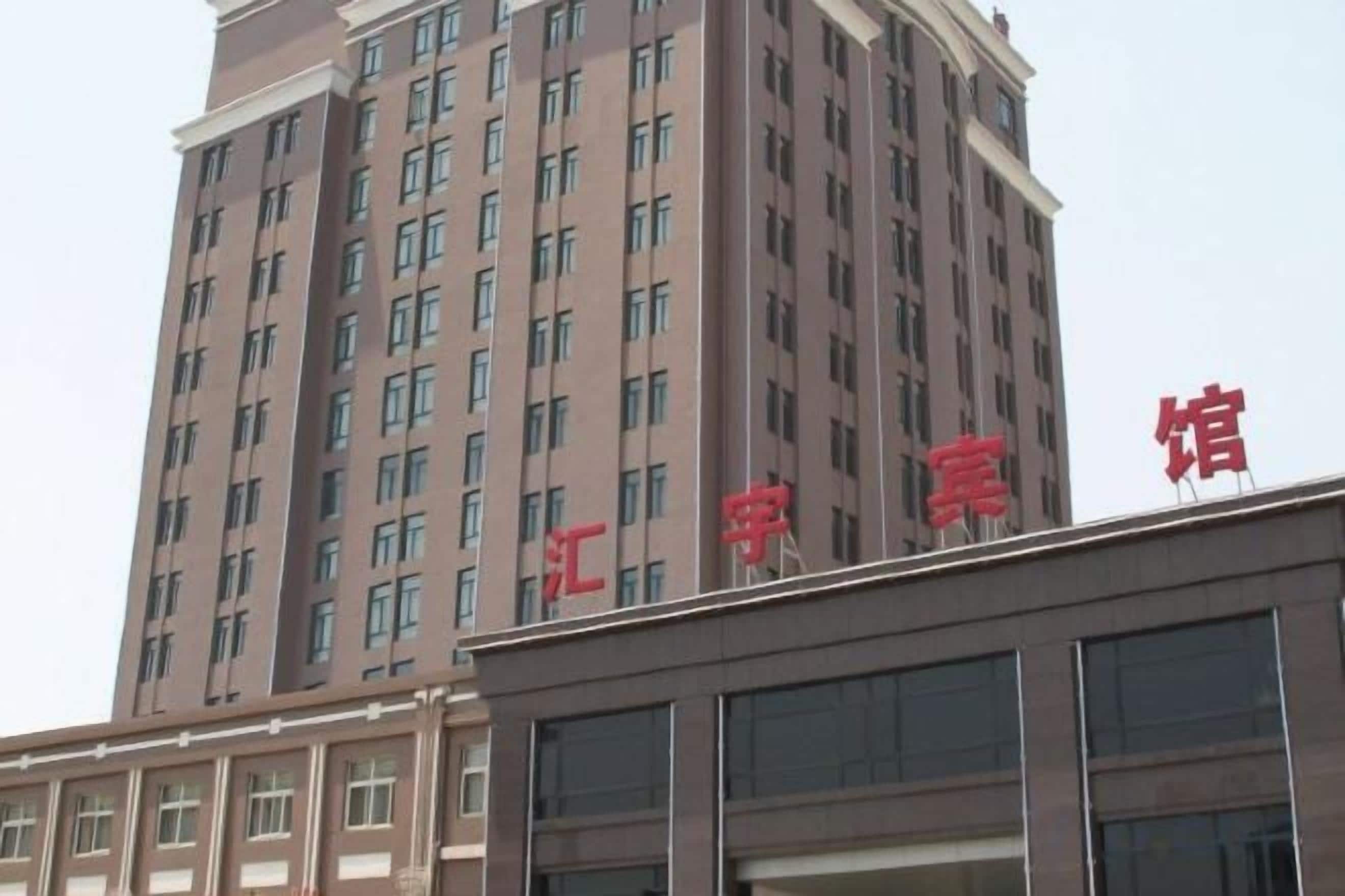 A multi-story building with a prominent red sign on the top.