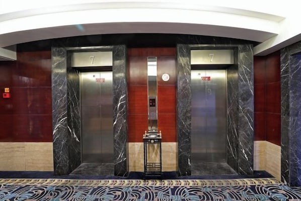 A modern elevator with marble walls and a patterned carpet. - Hangzhou Huiyu Hotel (Hangzhou)