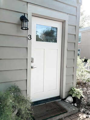 A white door with a small window above it, a mailbox, and a doormat with "WELCOME" written on it. - The Southern Charm (Beaufort)