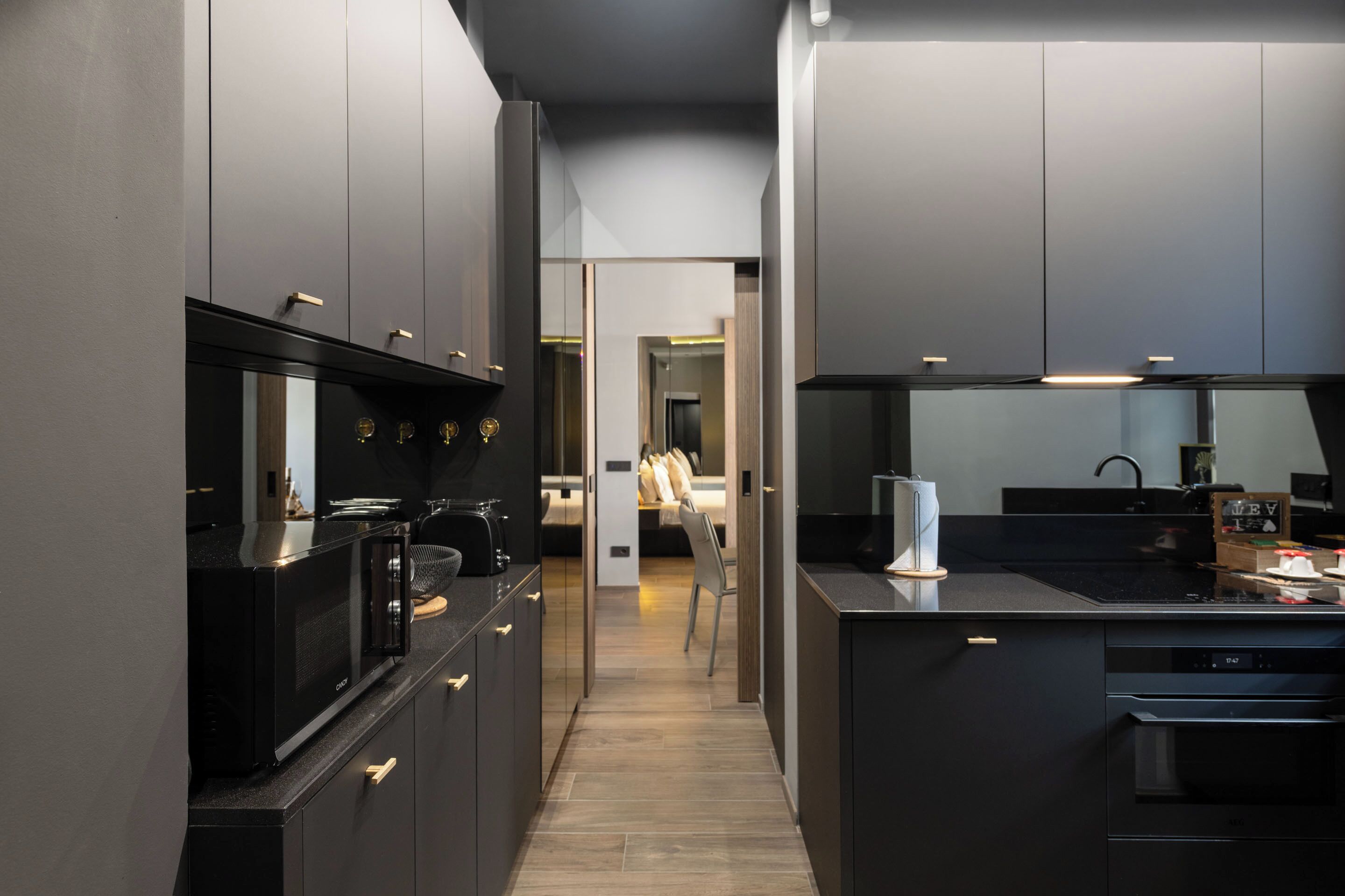 Una cocina moderna con armarios oscuros, una isla central y un microondas.