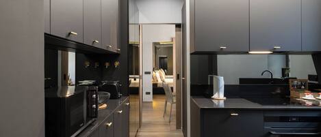 A modern kitchen with dark cabinetry, a central island, and a microwave.